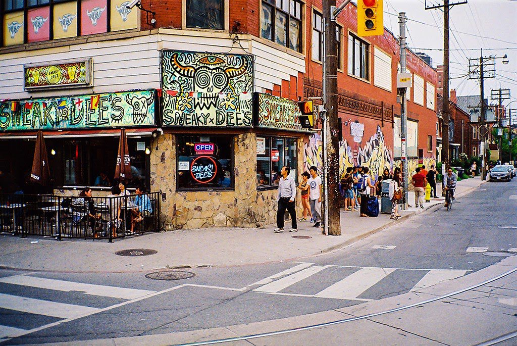 A daytime photo of the exterior of Sneaky Dees at College and Bathrust.