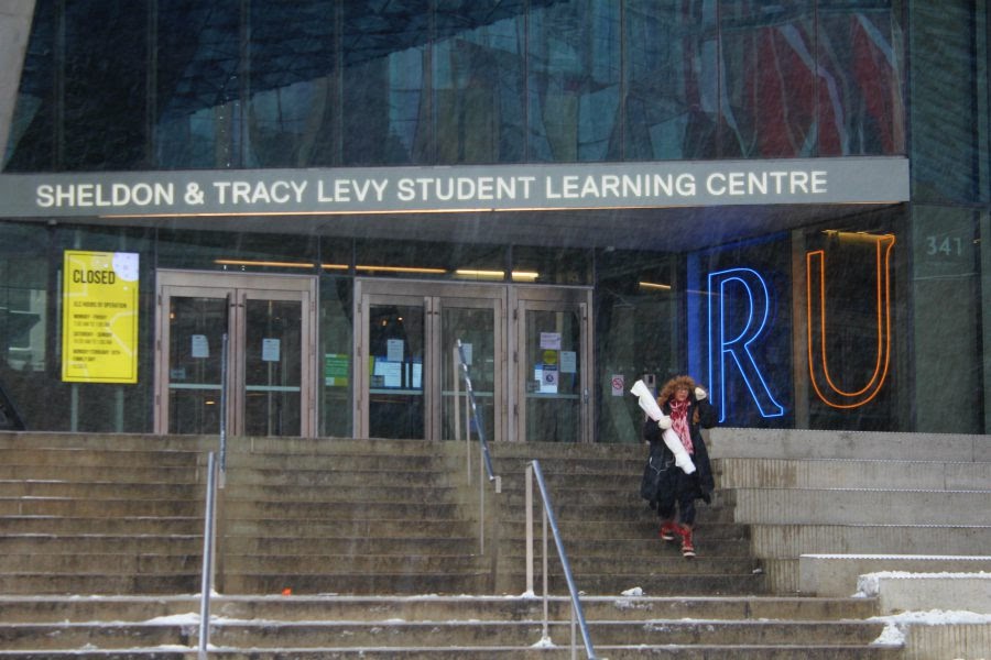 Students stand outside the steps of a building at Ryerson University