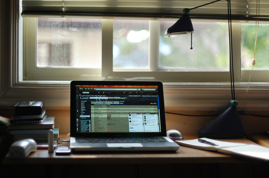 a macbook laptop opened on a desk with an email tag opened