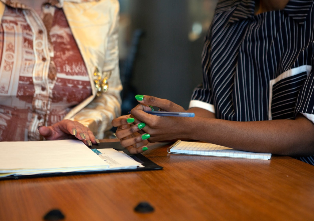 a pair of hands can be seen crossed over on an oak table 