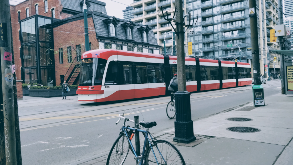 a red and white streetcar moves along an empty street