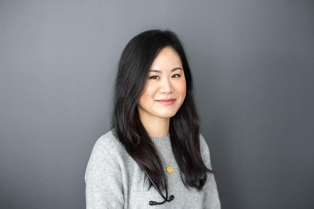 a young asian woman smiles at the camera