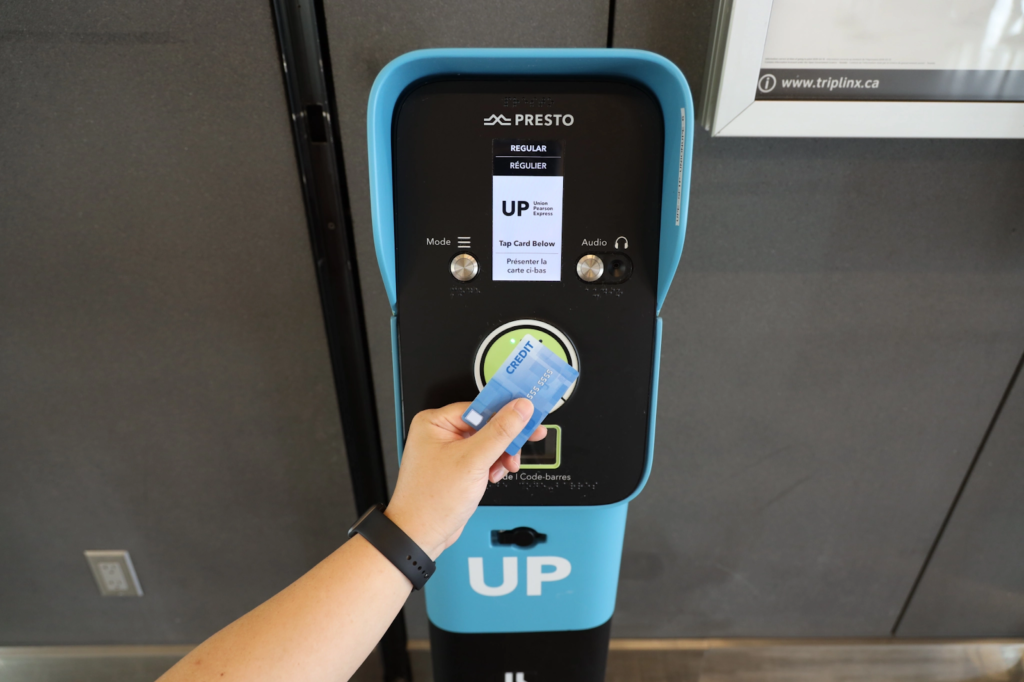 a person taps their card on a machine for fare collection