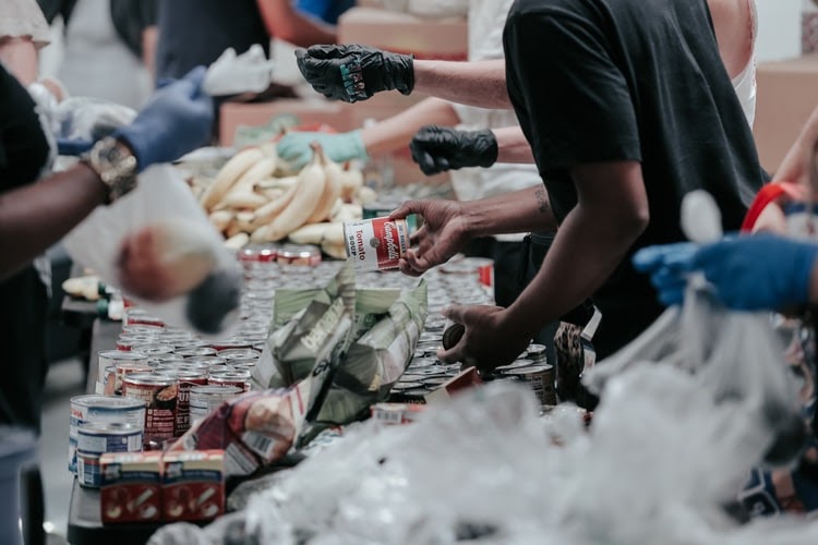 a close up shot of people giving food to others across a table