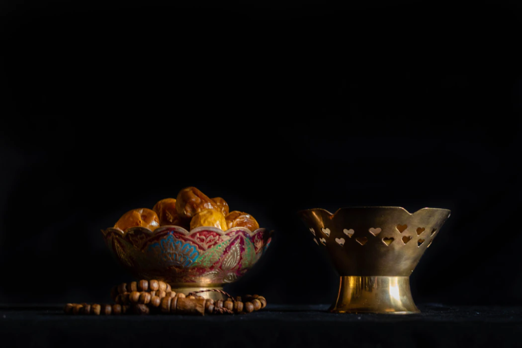 two golden bowls with sweets inside are side by side on a black table