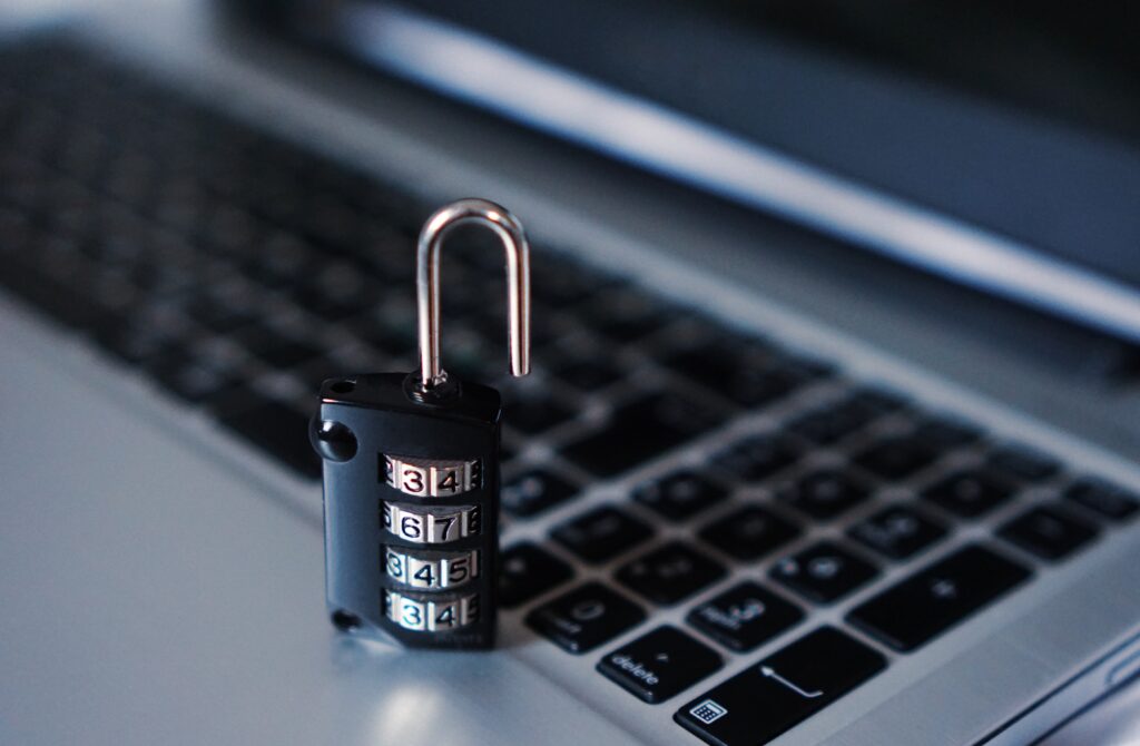 An opened lock, sitting on a Apple laptop.