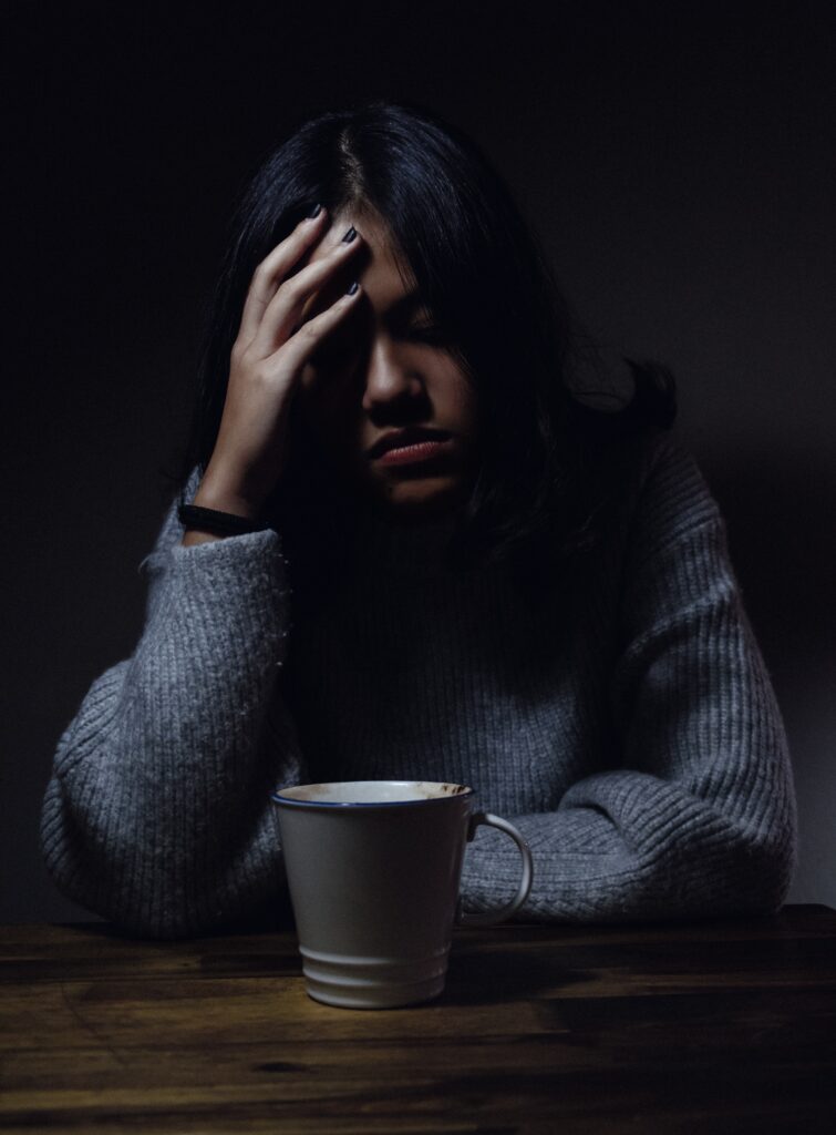 Photo of girl looking depressed with her head leaning against her hand.