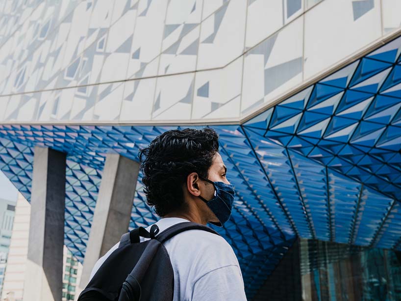 Photo of a student outside of the SLC wearing a black mask.