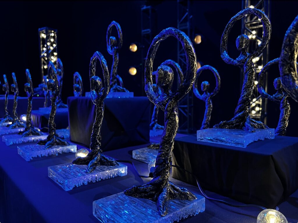 A bunch of Dora Awards sitting on a table in the dark.