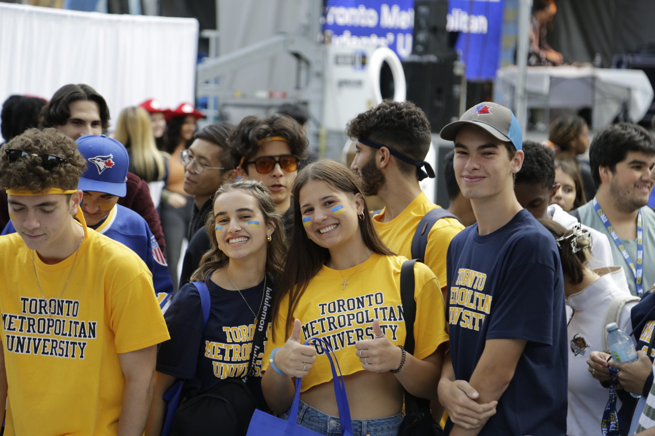 A photo of students smiling at the camera wearing TMU t-shirts.