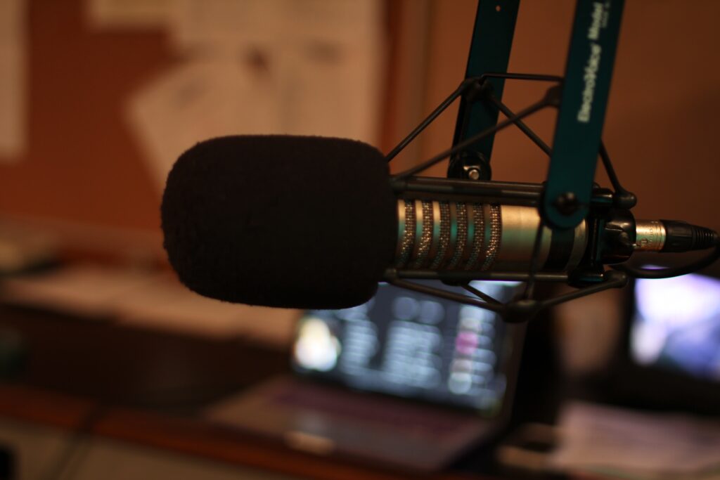 Microphone in front of blurred laptop screen.