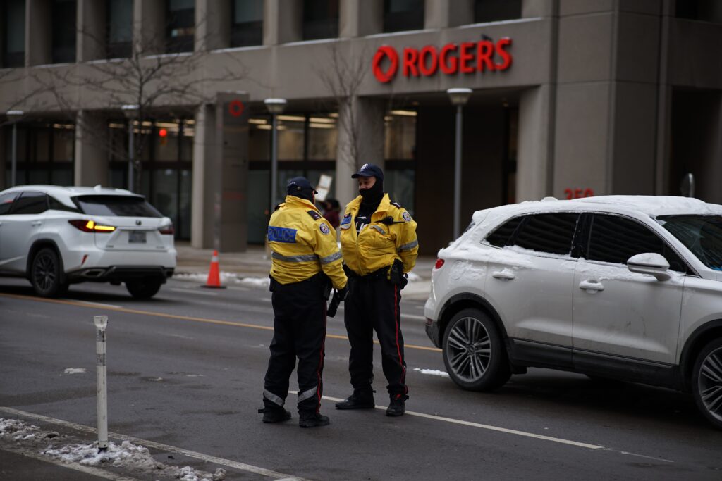 two Toronto police officers outside a Rogers building