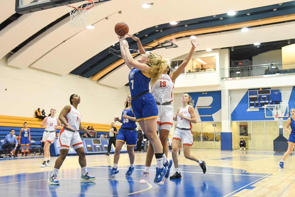 Farwell trying to score a field goal under the basketball net at home court.