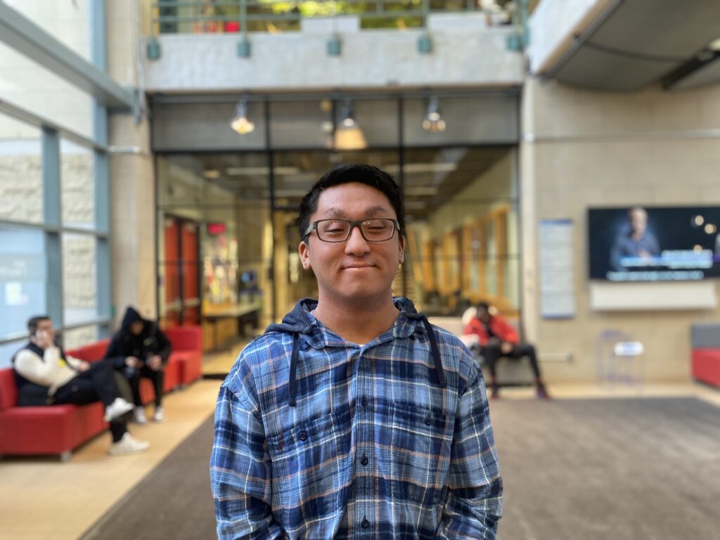 Josh Chang stands in the middle of the Rogers Communication Centre on campus.
