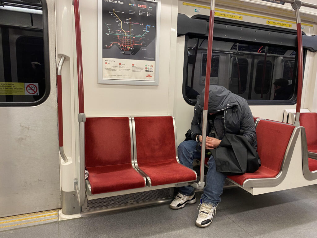 A man sleeps on the TTC on Feb. 13, 2023.