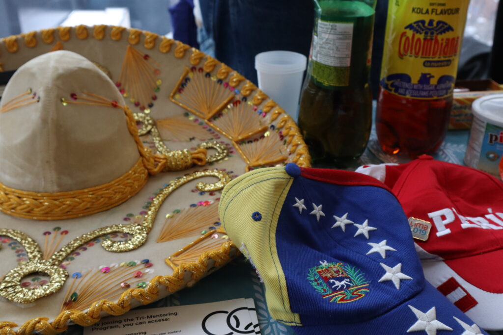 a tan sombrero with gold embellishings and two ball caps with Latin American inspired designs