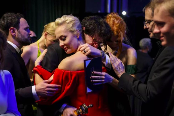 Daniel Roher andYulia Navalnaya embrace on the Oscar's stage.