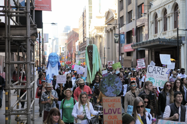 Street full of people marching with signs protesting climate change
