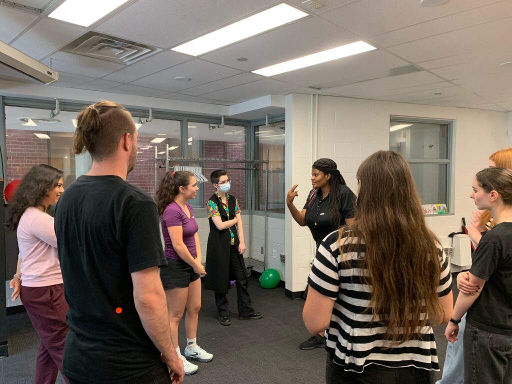 Participants in empowerment self-defence workshop gather around their instructor. 