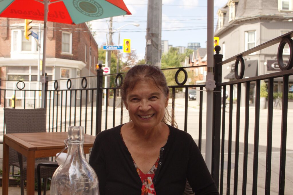 Anishinaabe artist and OCAD professor Bonnie Devine sitting outside a restaurant in Toronto.