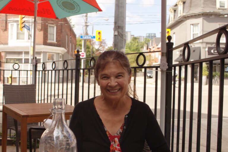Anishinaabe artist and OCAD professor Bonnie Devine sitting outside restaurant in Toronto.