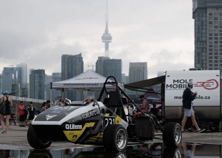 Toronto Met Formula Racing's 2022 racecar with Toronto's skyline in the background.