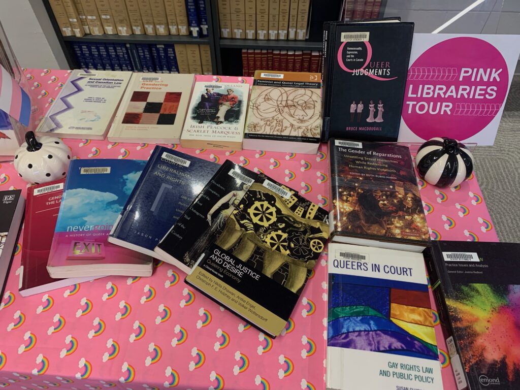 Display of books about the 2SLGBTQ+ community laid out on a table. 