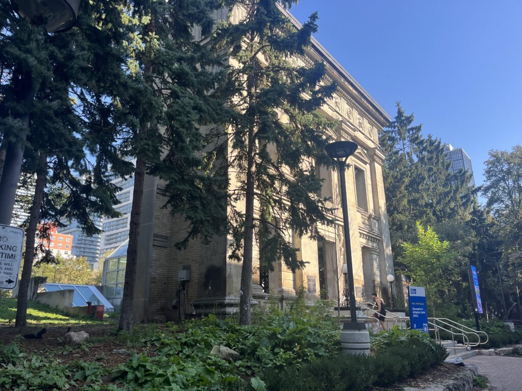 Photograph of the outside of a beige building on TMU’s campus that houses the Recreation and Athletic Centre (RAC)