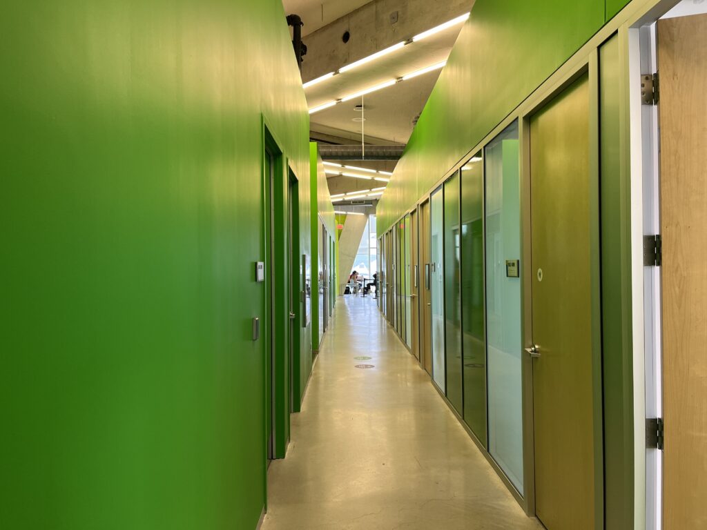 Photograph of a green hallway and doors leading to offices