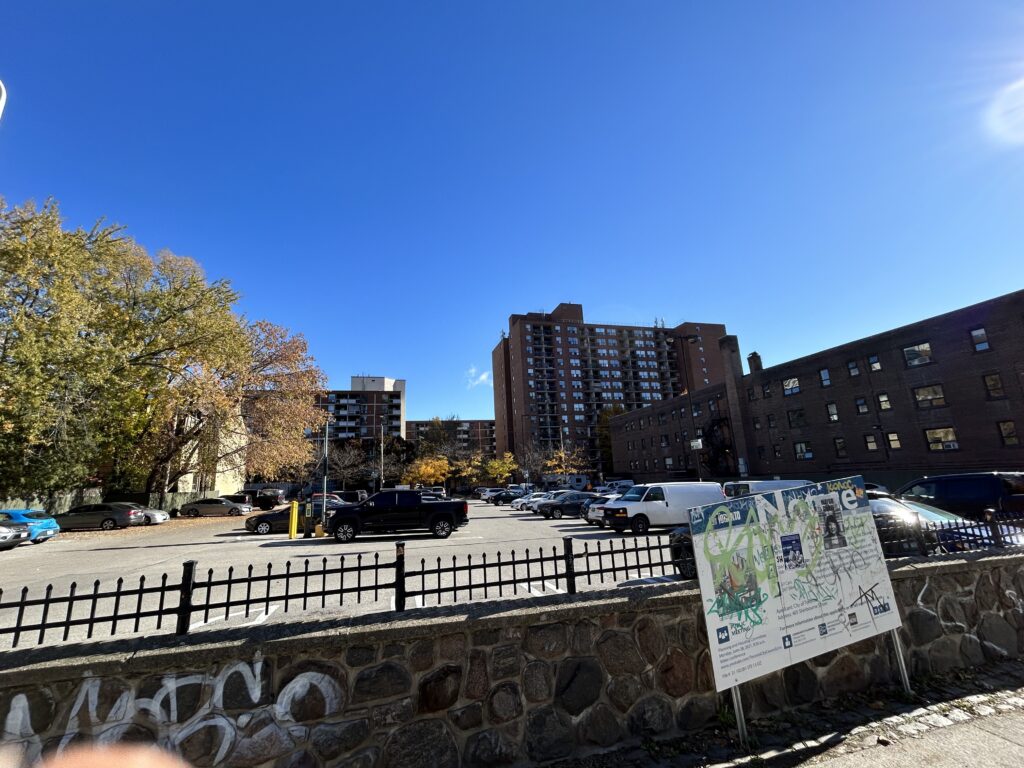 Parking lot is shown behind the notice board, which the city put a development notice stating it plans to build a future affordable residence complex here as part of its campaign to tackle the housing crisis