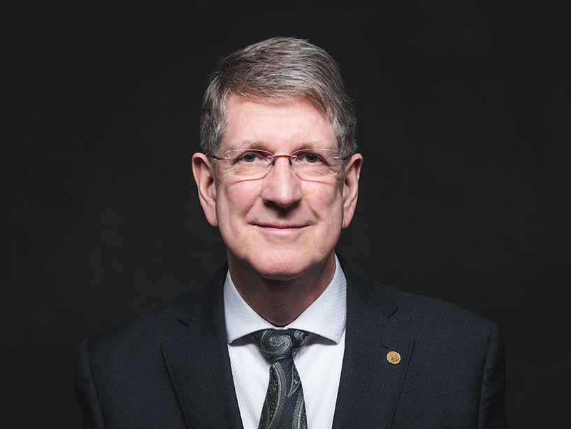 Portrait photo of Chief Justice J. Michael MacDonald against a black background