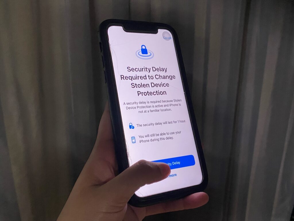 A hand holding an iPhone open on Apple's new Stolen Device Protection screen