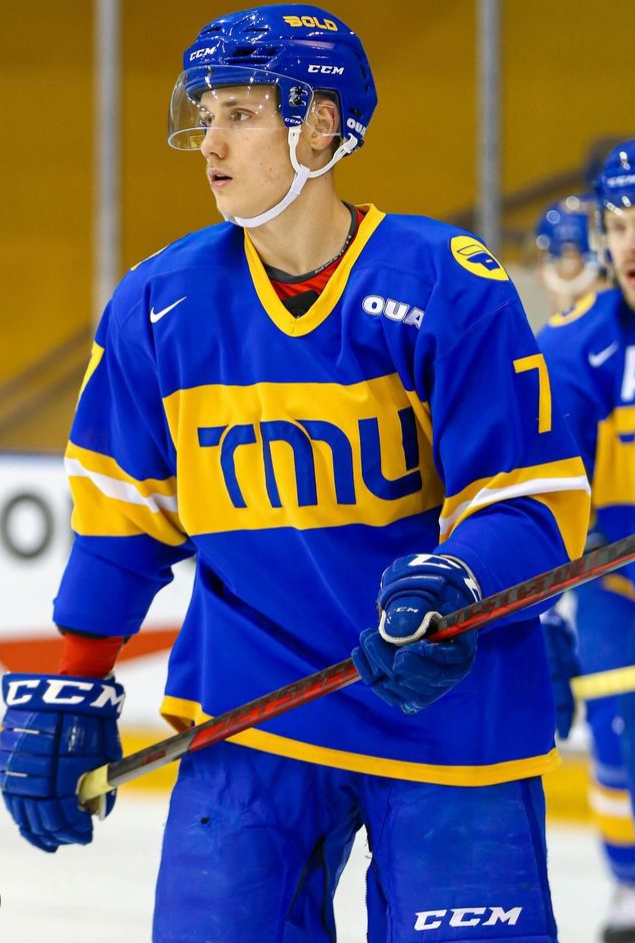 A person on the ice wearing a blue and yellow jersey.