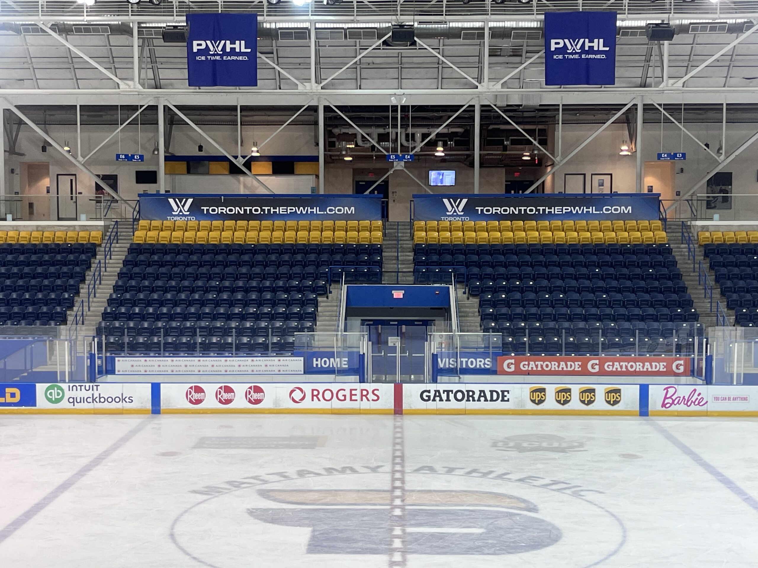 An empty ice sheet with rows of seats behind it. 