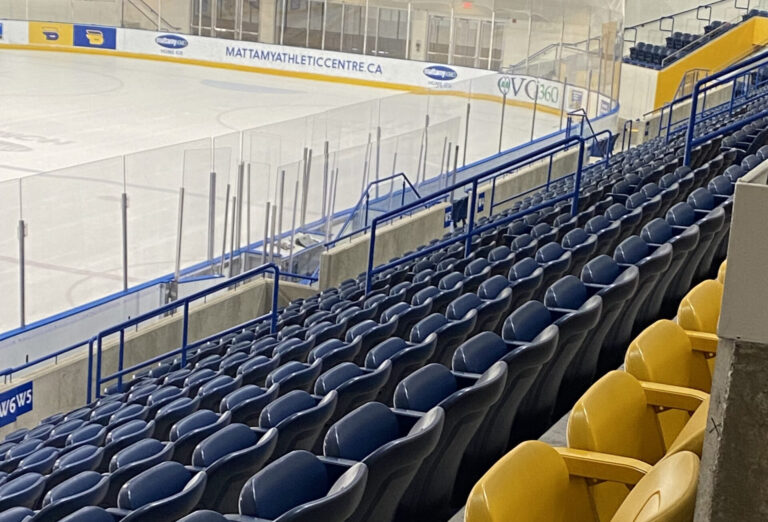 A section of empty blue and yellow seats