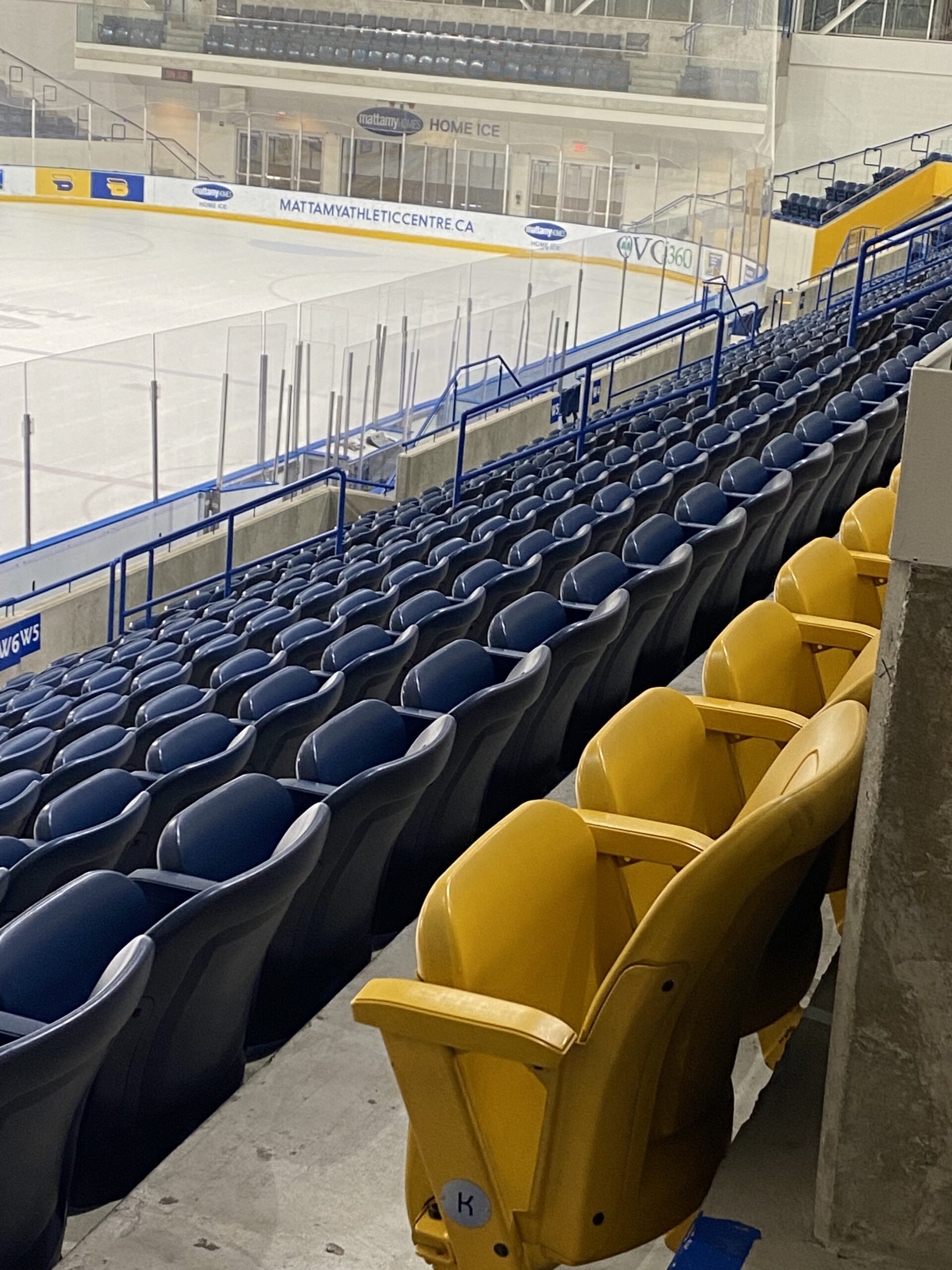 A section of empty blue and yellow seats 