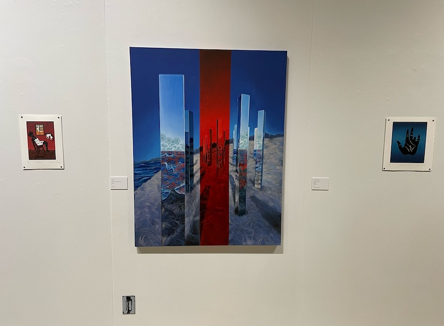 A painting of vertical columns in blue and red with two small paintings on opposite side.