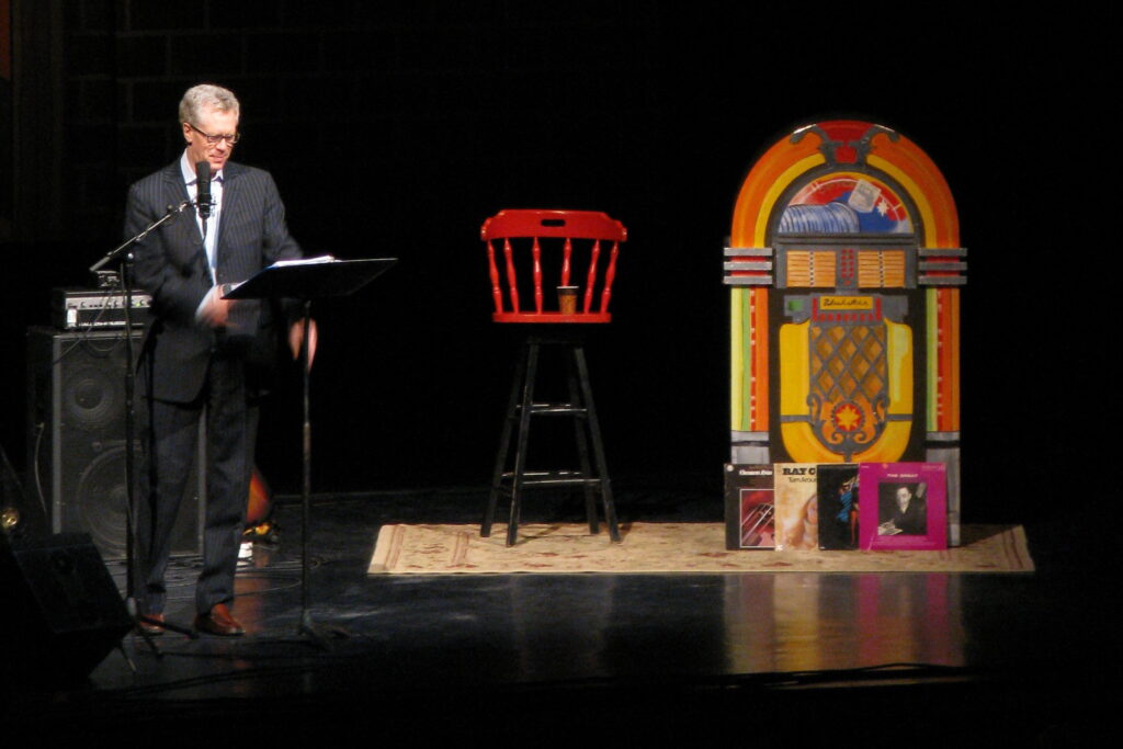 A photo of Stuart McLean on stage.
