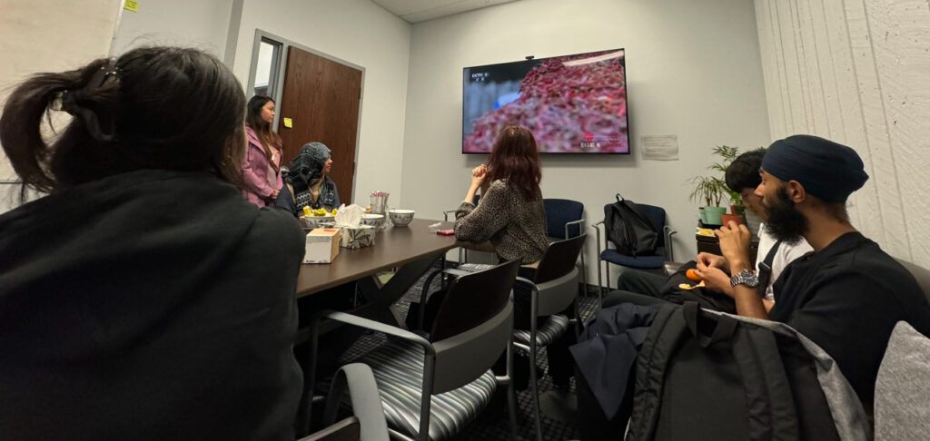 Participants gather to watch a online video about Chinese cuisine.