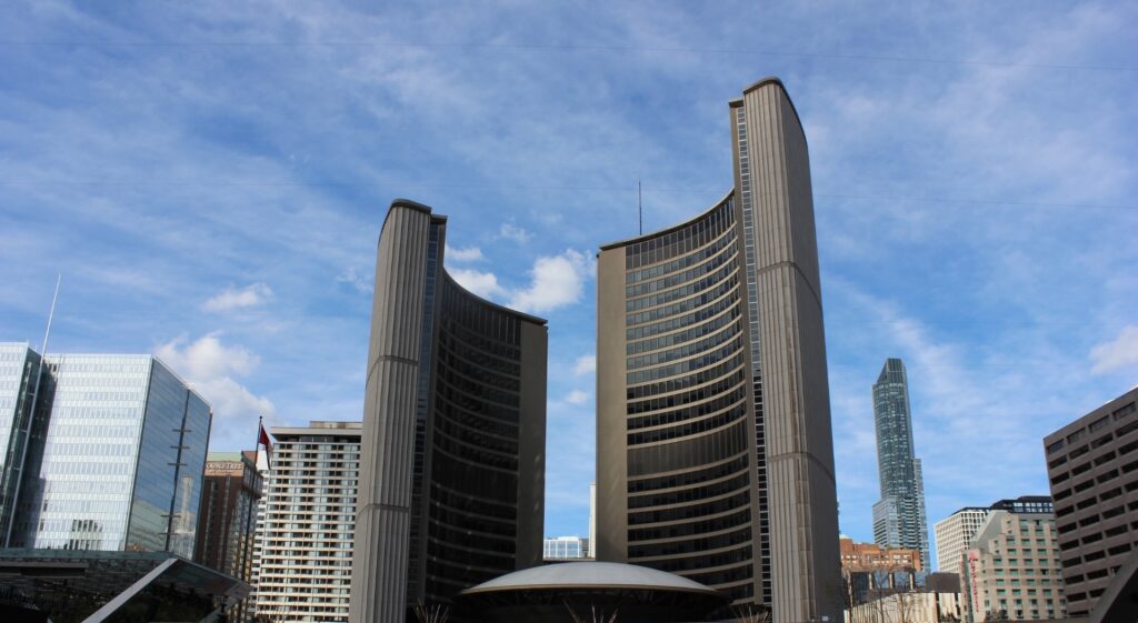 A photo of Toronto's city hall against a blue sky.