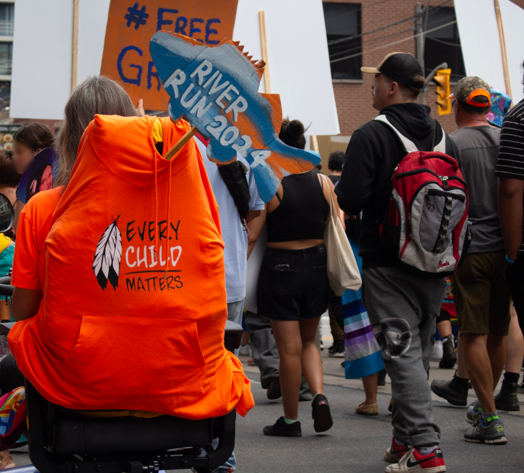 Two signs reading "#free Grassy" and "River Run 2024"