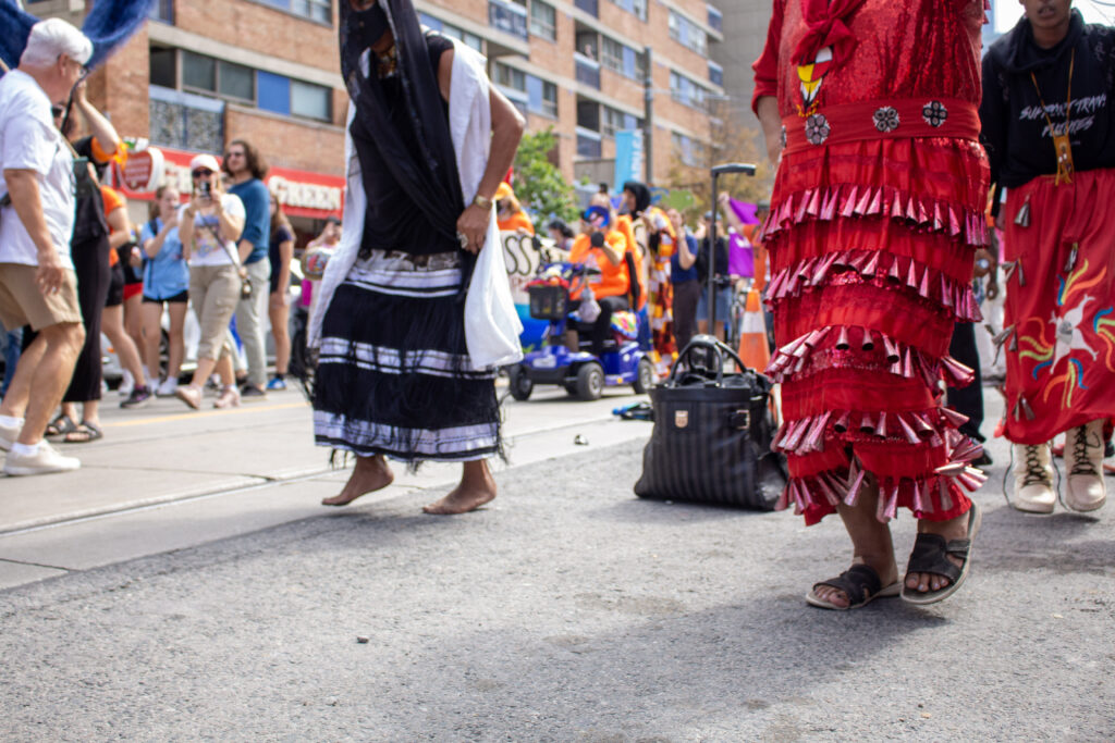 Women dancing down the middle of Dundas st.