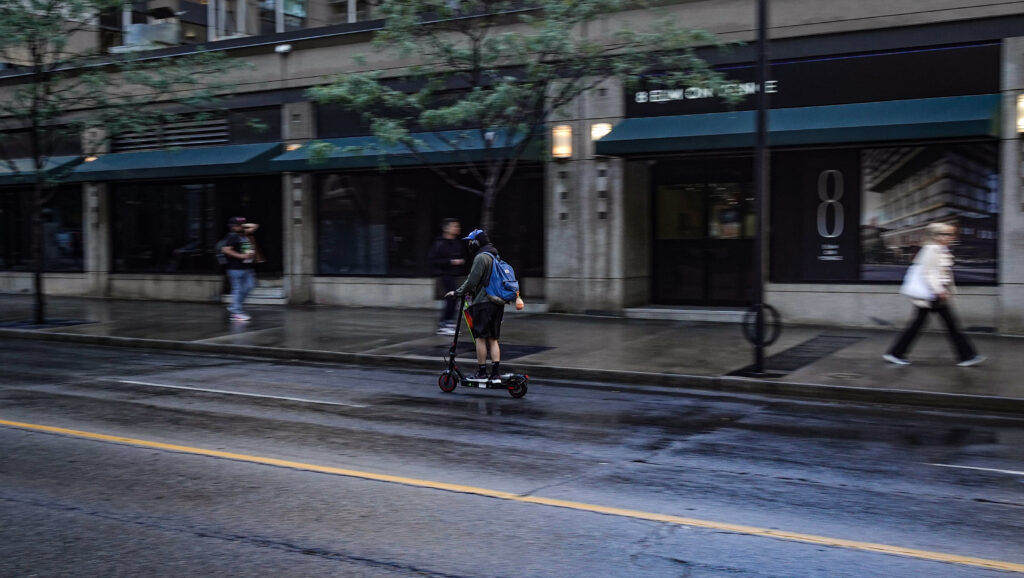 A rider on an e-scooter travels along Bloor Street. (Photo credit: Mehmet Oner)
