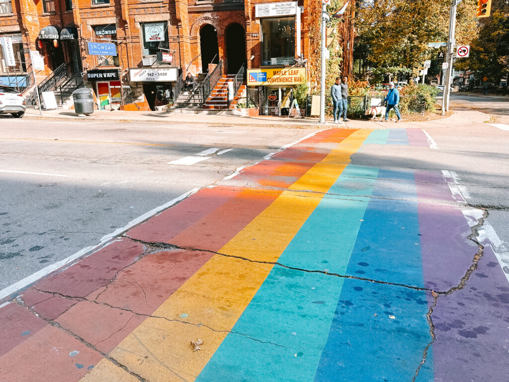 Road with rainbow cross walk - from left to right, red, orange, yellow, green, blue and purple