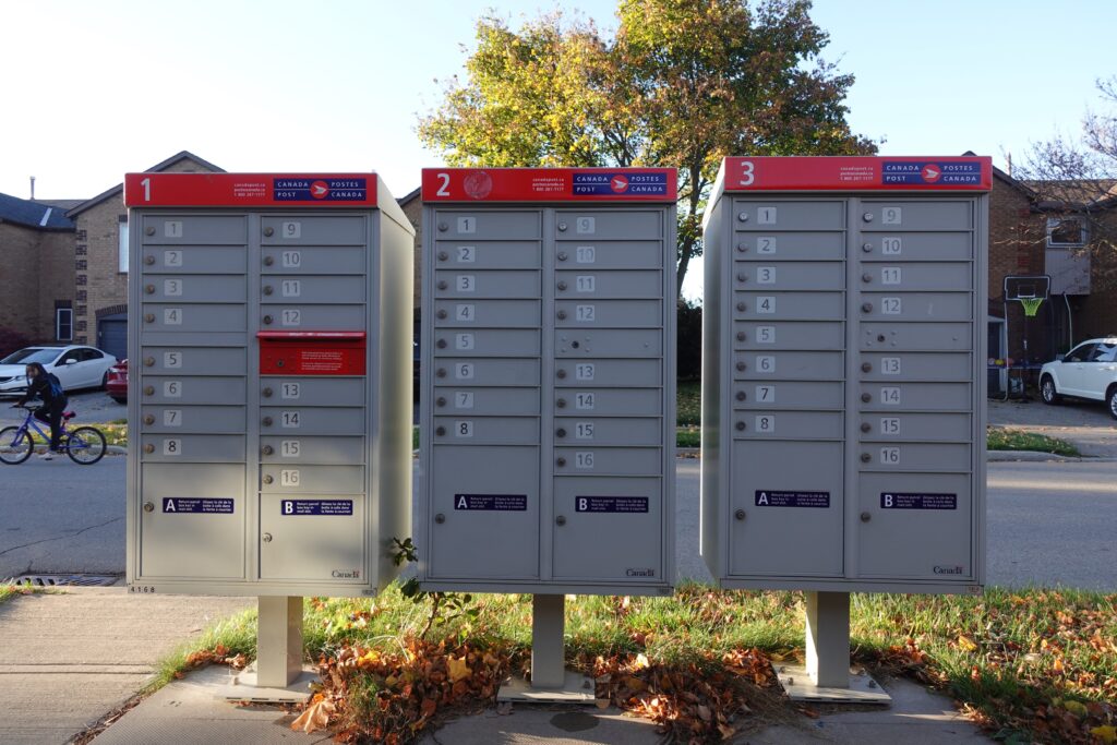 Three red and grey mailbox lockers side by side