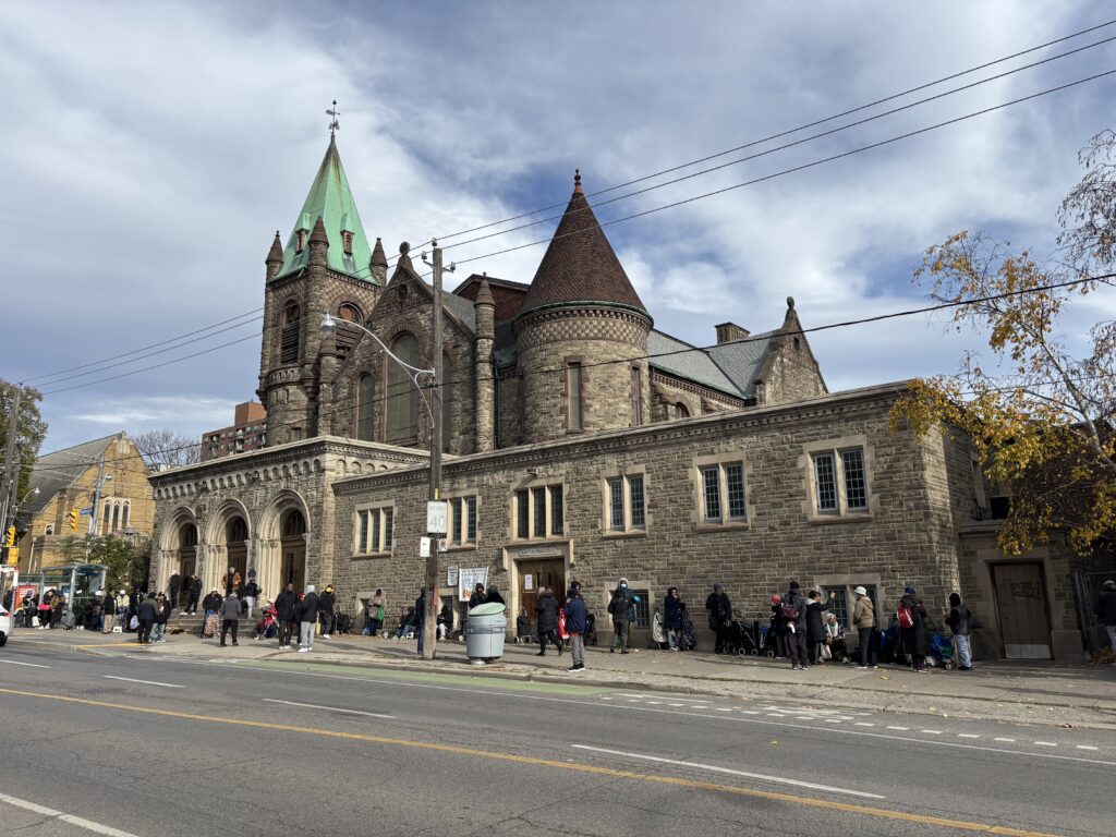 A line of people in front of a church food bank