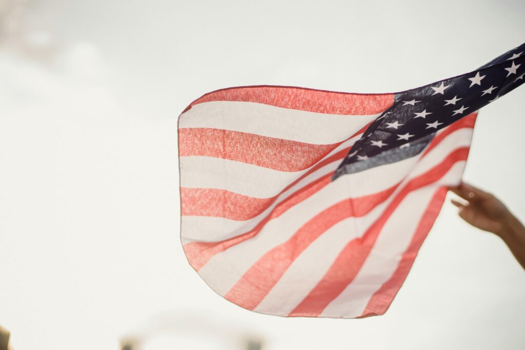 A photo of an American flag waving in the air.