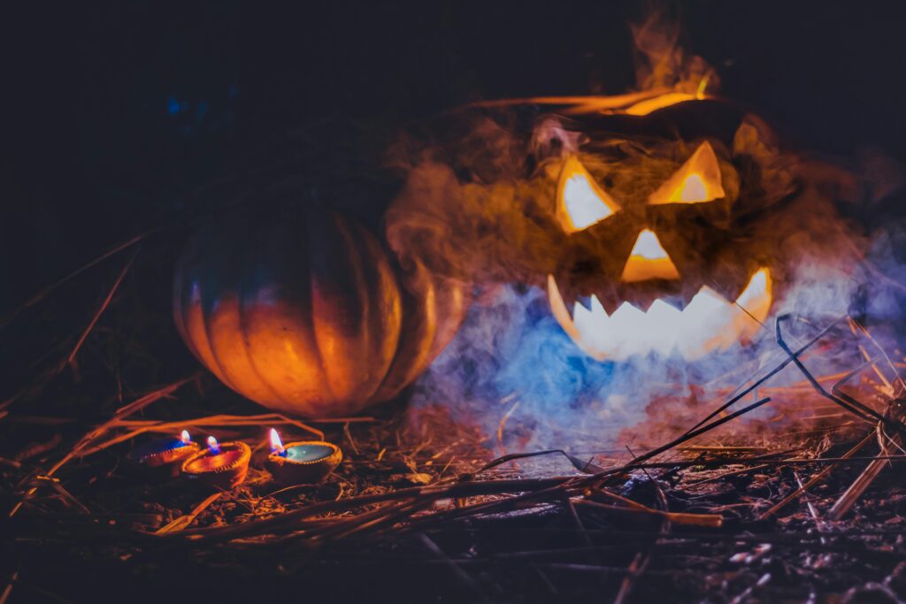 Jack-O-Lantern, Pumpkin, and Diyas on grass and sticks