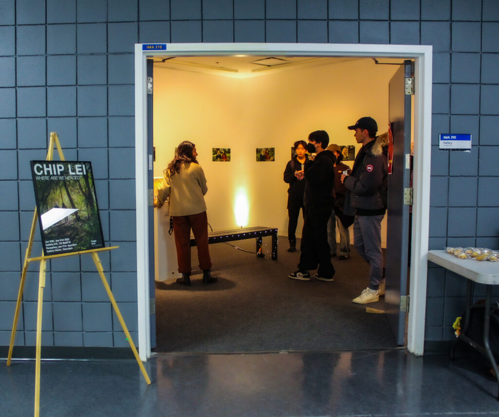 Five people talking inside a warmly lit room.