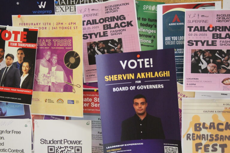 A corkboard covered with colourful posters, with a campaign poster that reads "Vote Shervin Akhlaghi for board of governers"